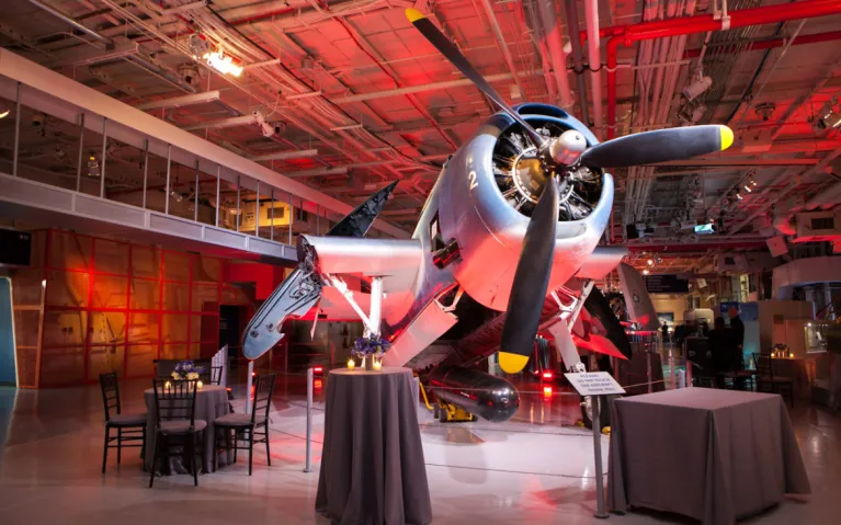 Tables and chairs set up in front of the Avenger aircraft