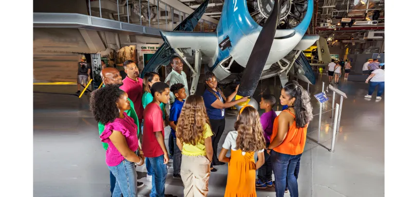 Group of visitors with a museum guide in front of the Avenger