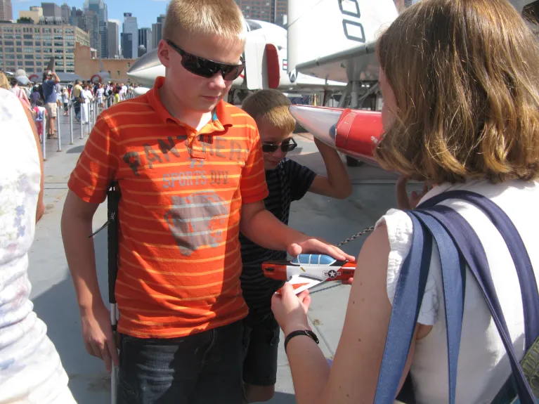 Children with visual impairments taking part in a tour on the Intrepid Museum flight deck.