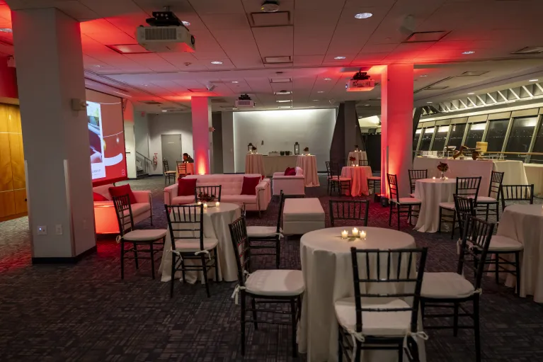 Great Hall cocktail reception setup with red uplighting, white lounge furniture with cocktail tables