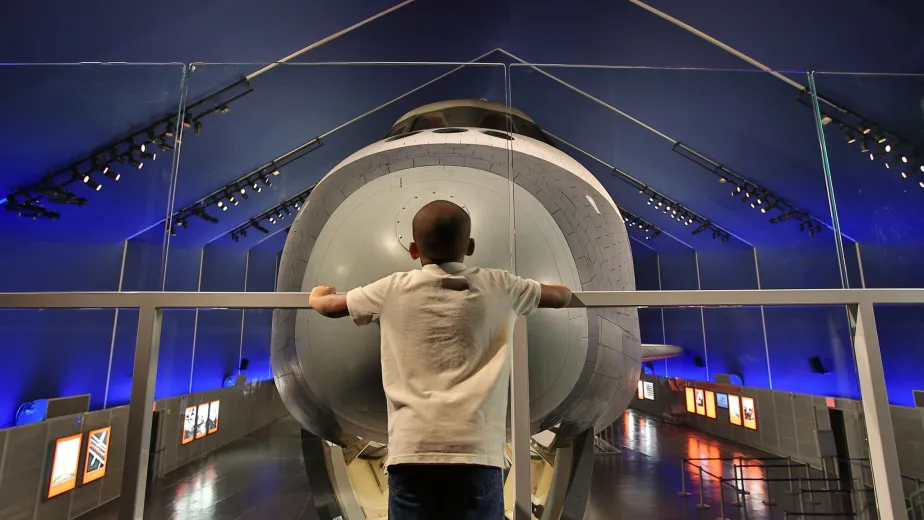 A young boy gazes out at the Entreprise in the Museum&#039;s Space Shuttle Pavillion.