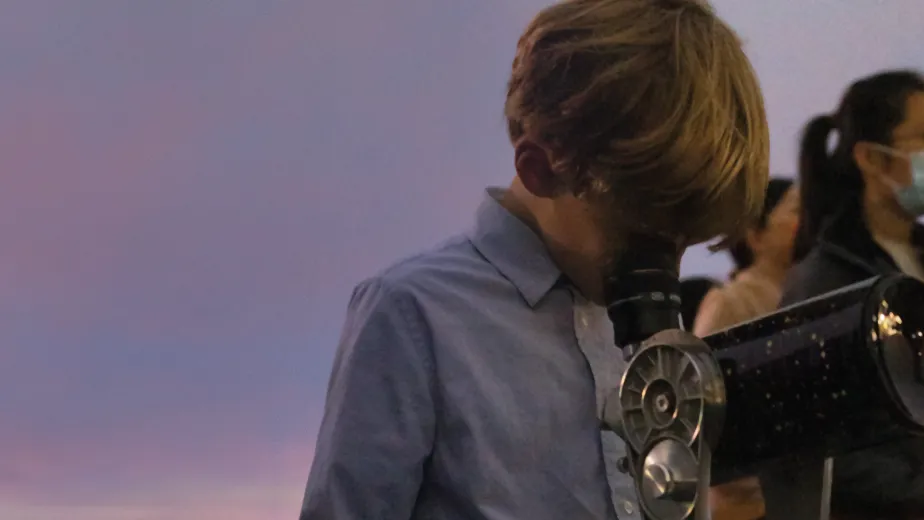 A young explorer through the telescope on the Intrepid flight deck