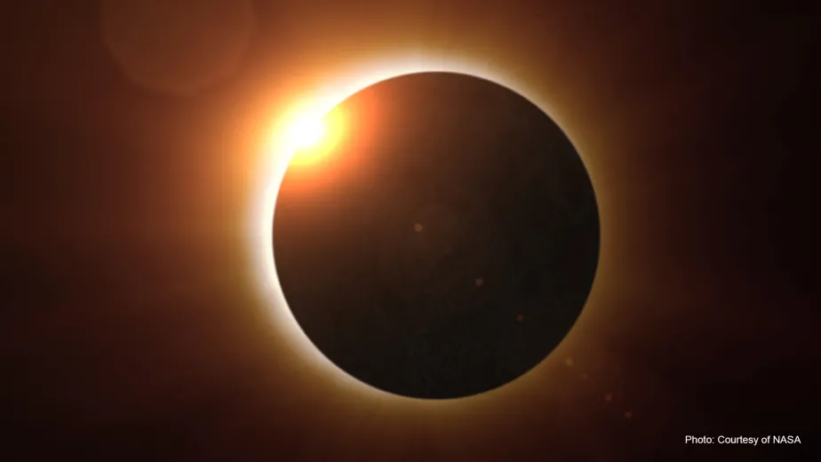 Solar eclipse casting shadow over landscape.