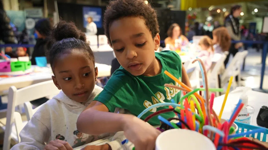 Two children engaged in an arts and crafts activity.