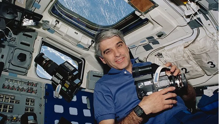 Astronaut and commander Sidney Gutierrez in Space Shuttle Endeavour, with a Hasselblad camera and a Casio databank 