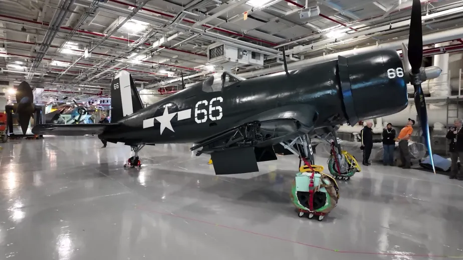 Corsair aircraft inside the Intrepid Museum's hangar deck being moved into its permanent exhibition spot.