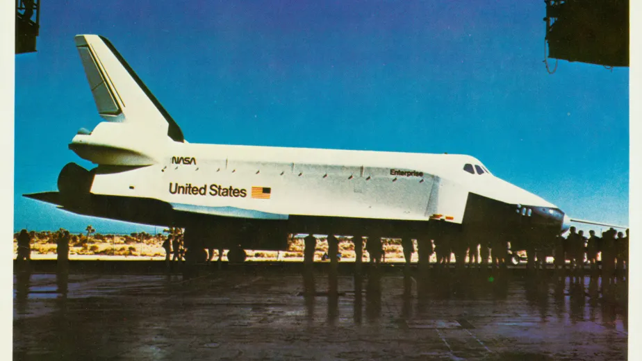 Space Shuttle Enterprise with a crowd of people taking pictures.