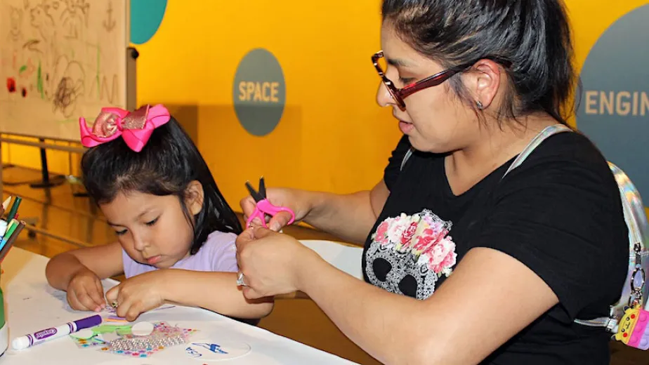 A family participating in a hands-on activity at the Intrepid Museum