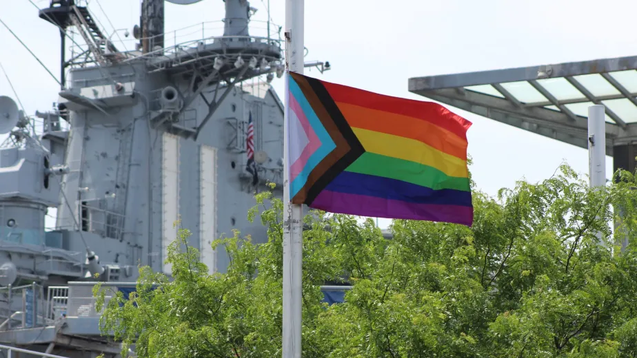 Pride flag waving in front of Pier 86 at the Intrepid Museum