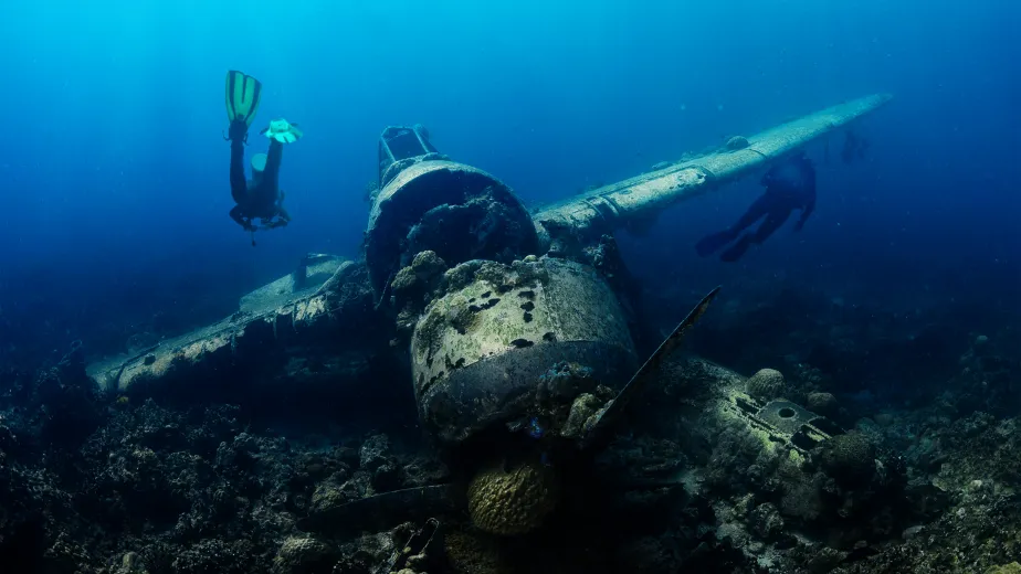 A scuba diver surveying an underwater plane wreck