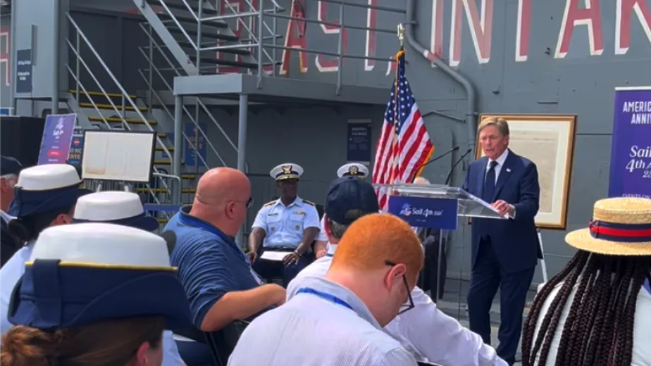 Ken Fisher speaking at a Sail4th 250 press conference on the Intrepid Museum’s flight deck.