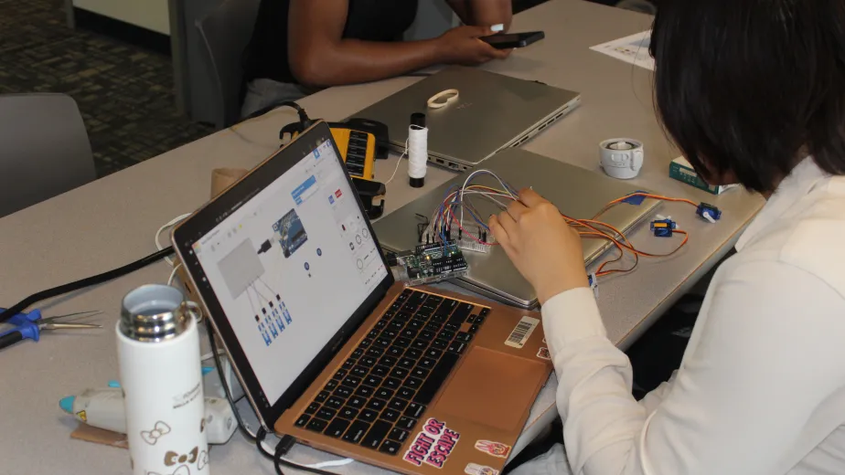 Young adults working with laptops and various electronics