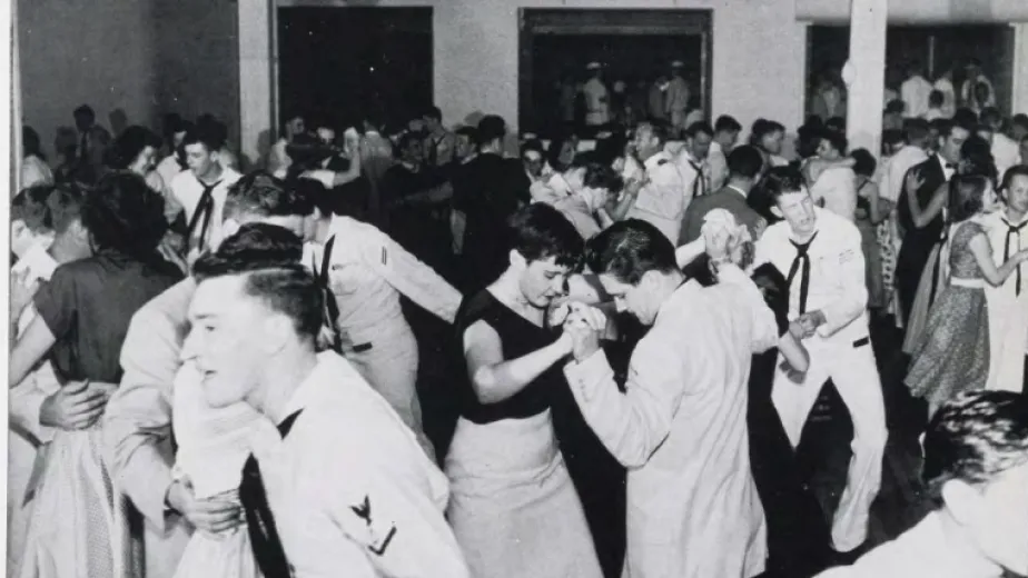 Black and white photo of couples dancing. The men are wearing sailor uniforms.
