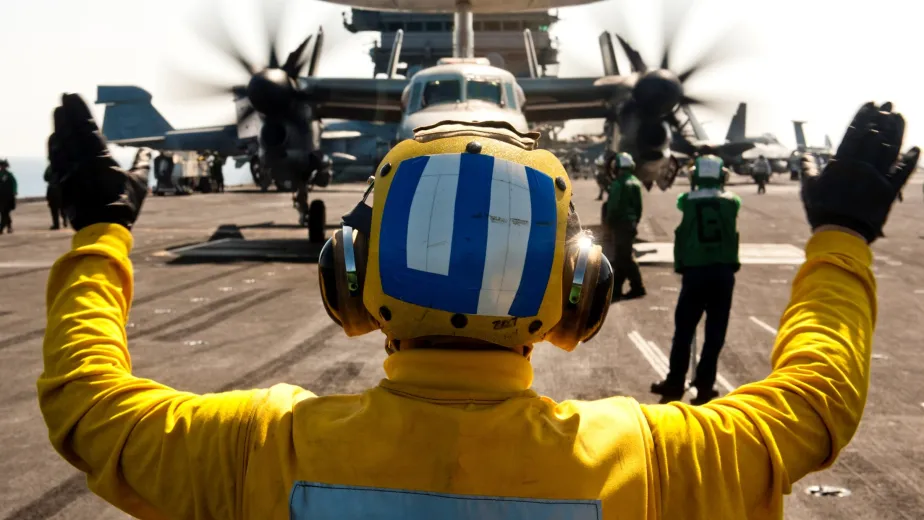 A Landing Signal Officer directing a plane on Intrepid's flight deck.