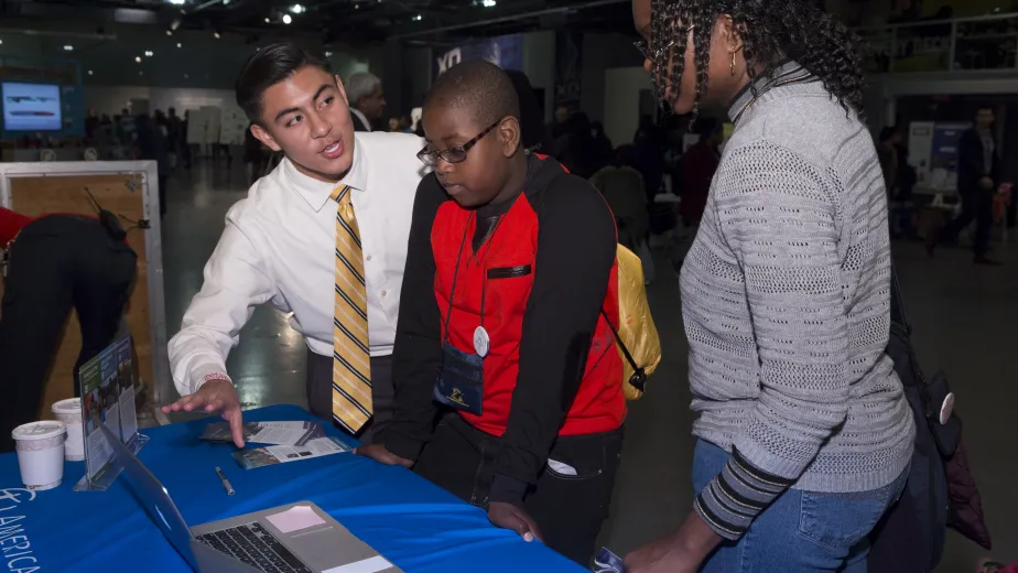 Family participating in a hands-on activity at an event table.