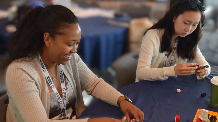 Two women engaged in construction with snap-together building blocks