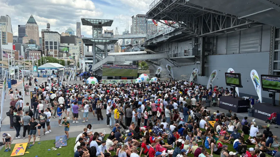 Visitors watching a soccer match on Pier 86 during an outdoor World Cup Watch Party.